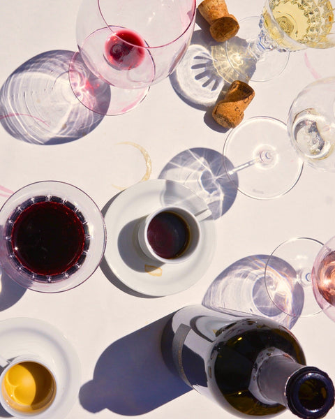 Wine bottle and glasses with corks on white background