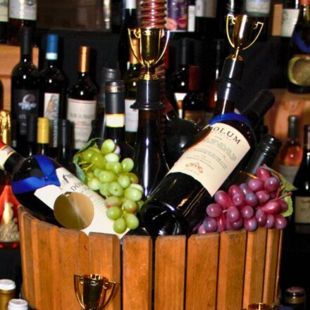 Wines, grapes, and trophies in small vintage grape press