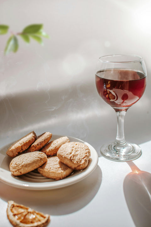 Wine and shortbread cookies with an orange peel on the side