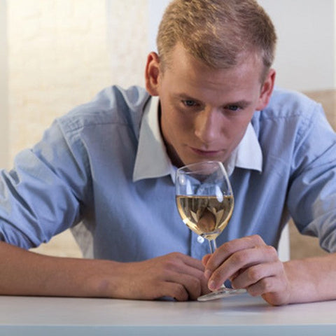 Man smelling glass of white wine